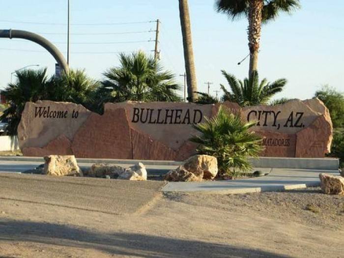 Welcome to Bullhead City, Arizona stone sign surrounded by palm trees.